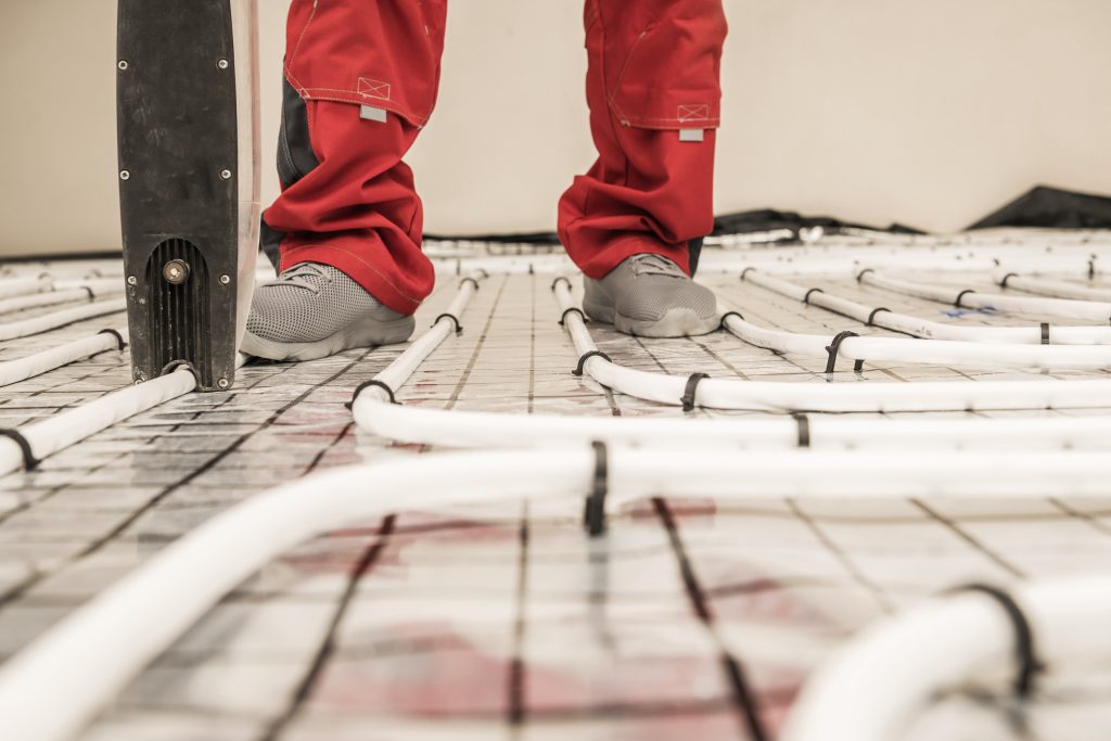 Radiant Floor Heating Pipe Installation Performed by Professional HVAC Worker